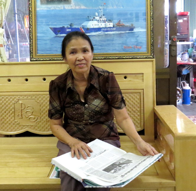 Bà Phạm Thị Kim Liên bên cuốn sổ dán các bài báo Tuổi Trẻ viết về hai con trai thuyền trưởng cảnh sát biển Lê Hải Trường, Lê Tiến Kim - Ảnh: DUY THANH