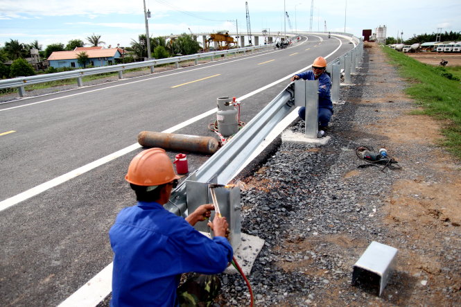 Công nhân đang hoàn tất việc laắp rào chắn bên đường dẫn lên cầu Mỹ Lợi