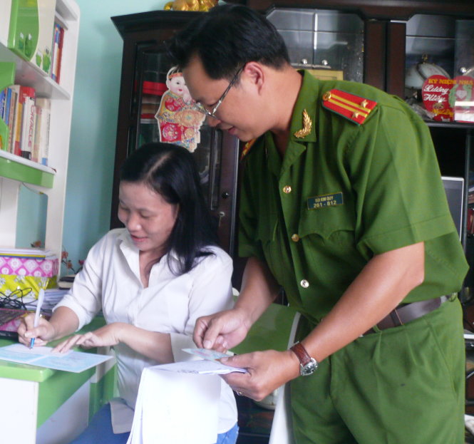 Tổ công tác hướng dẫn làm mới CMND ngay tại nhà cho chị Dương Việt Hằng Ảnh: SƠN BÌNH