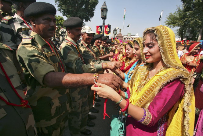 Lực lượng an ninh biên giới Ấn Độ (trái) được đeo vòng cầu may trong dịp lễ của đạo Hindu tại điểm đường biên ở ngoại ô Amritsar, Ấn Độ ngày 29-8    - Ảnh: Reuters