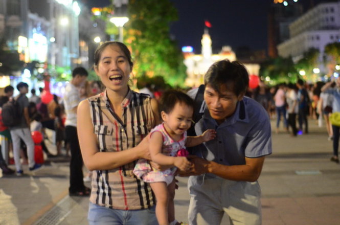 Một gia đình vui vẻ trên phố đi bộ Nguyễn Huệ trong ngày lễ -Ảnh: Thanh Tùng
