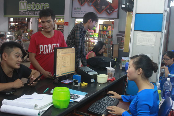 Hành khách hỏi nhân viên bán vé tại ga Sài Gòn về quy trình mua vé tàu điện tử - Ảnh: Đức Phú