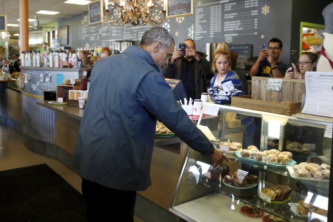 Tổng thống Obama mua bánh trong cửa hàng Snow City Cafe ở thành phố Anchorage, bang Alaska ngày 1-9 - Ảnh: Reuters