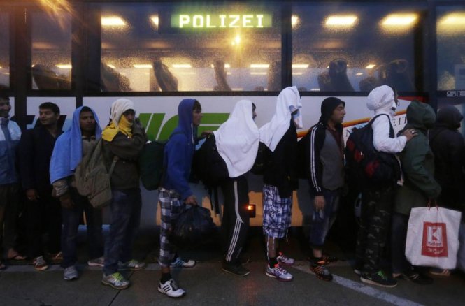 Hàng dài người dân tị nạn xếp hàng lên xe buýt để đi đến Áo - Ảnh: AP