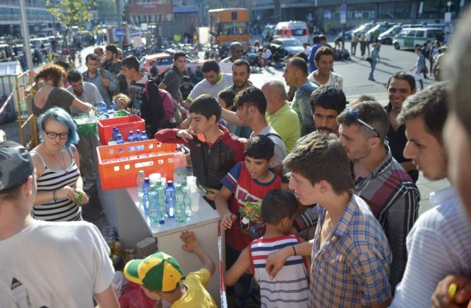 Người dân địa phương cung cấp nước uống miễn phí cho dân tị nạn - Ảnh: Reuters