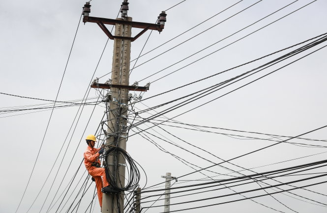 Cách xử lý lỗ thường thấy của các tập đoàn lớn ở Việt Nam là... tăng giá bán. Trong ảnh: công nhân sửa chữa lưới điện tại thị trấn Kbang, huyện Kbang, tỉnh Gia Lai Ảnh: TIẾN THÀNH