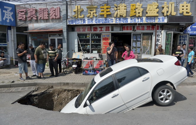Xe sụp “hố tử thần” trên đường phố thủ đô Bắc Kinh của Trung Quốc ngày 6-9. Cơ sở hạ tầng của Trung Quốc chưa đạt chất lượng xứng đáng với nền kinh tế lớn - Ảnh: Reuters