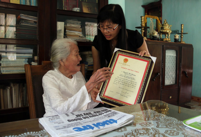 Người cháu nội của bà Hoàng “khoe” thiếp mừng thọ bà tròn 105 tuổi do Chủ tịch nước gửi tặng năm ngoái  Ảnh: NGỌC HIỂN