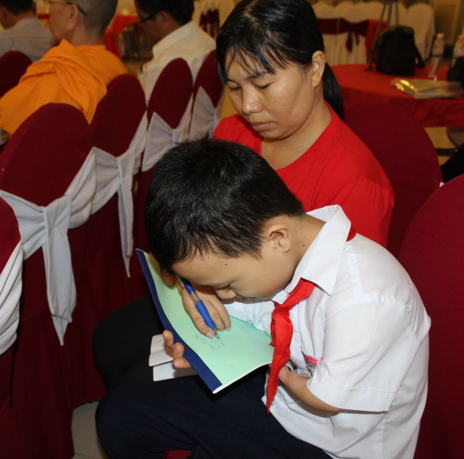 Tiến đang viết bằng hai ngón tay, tại một hội nghị dành cho người khuyết tật vượt khó ở tỉnh Ninh Thuận vào tháng 11-2014 mà Tiến là đại biểu tiêu biểu  Ảnh: M.TRÂN