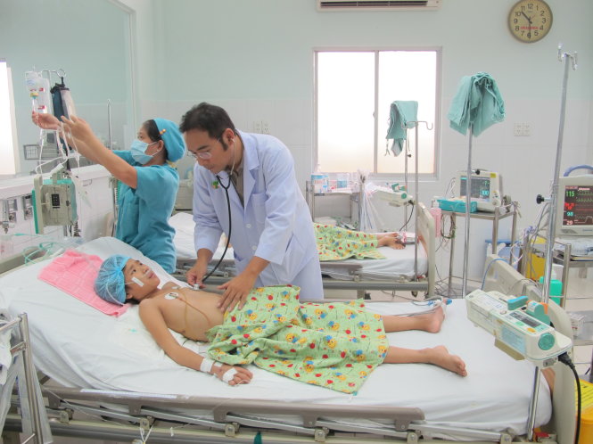 Chăm sóc một bệnh nhi sốt xuất huyết tại Bệnh viện Nhi Đồng 2 - Ảnh: THÙY DƯƠNG