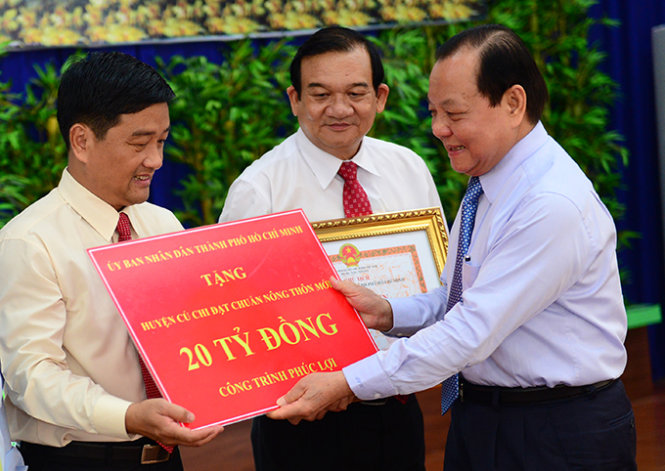 Ông Lê Thanh Hải - ủy viên Bộ Chính trị, bí thư Thành ủy TP.HCM - thay mặt lãnh đạo TP trao cho Củ Chi 20 tỉ đồng - Ảnh: Q.Định