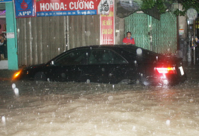 Người dân khốn khổ xoay xở trong nước mưa ngập ở phường Trảng Dài, TP Biên Hòa tối 8-9 - Ảnh: Thu Hoài