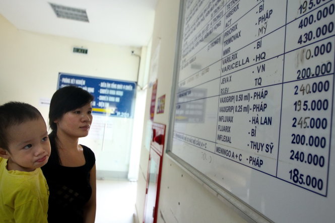 Ngày 14-9, một phụ nữ theo dõi bảng giá tiêm chủng trong một cơ sở y tế tại Hà Nội, trong đó có nhiều mức giá mới vừa được điều chỉnh - Ảnh: NGUYỄN KHÁNH