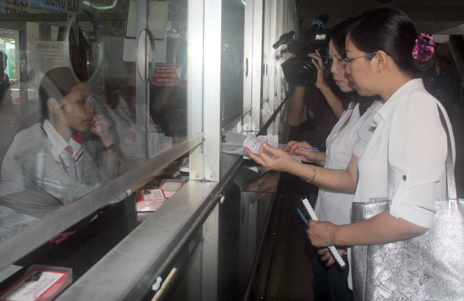 Thành viên đoàn kiểm tra kiểm tra việc giảm giá vé tại bến xe Miền Đông sáng 14-9 - Ảnh QUANG KHẢI