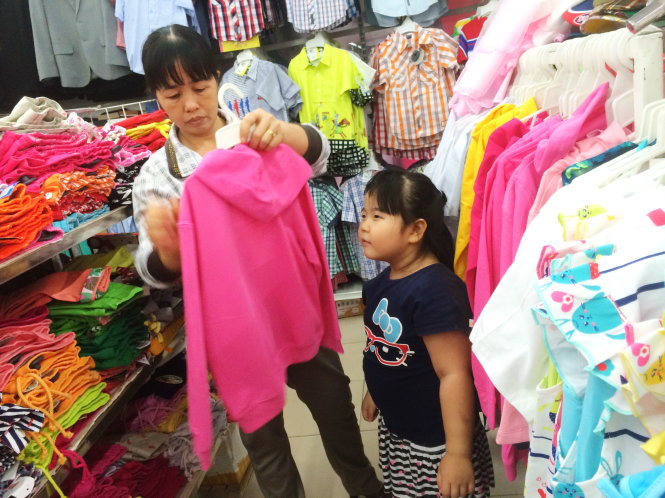 Khách hàng chọn mua quần áo may sẵn tại một siêu thị - Ảnh: T.V.N.