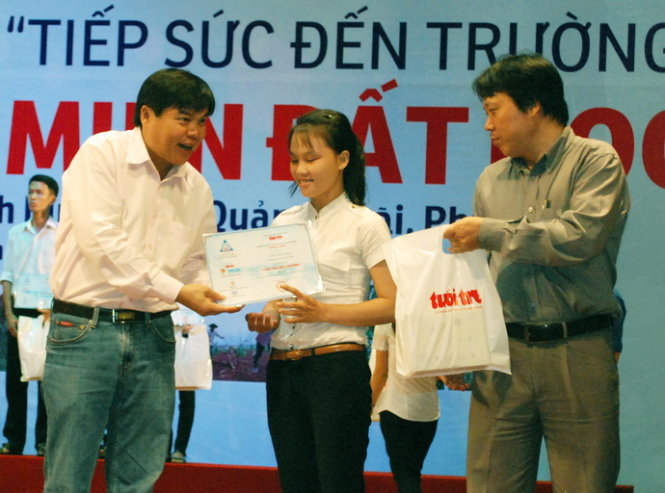 Ông Tăng Hữu Phong, tổng biên tập báo Tuổi Trẻ trao học bổng cho tân sinh viên vượt khó - Ảnh: Hoa Khá
