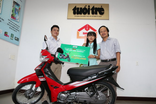 Ông Huỳnh Văn Mão (bìa trái) trao tặng xe máy cho Quỳnh tại văn phòng báo Tuổi Trẻ ở Huế - Ảnh: G.Hưng
