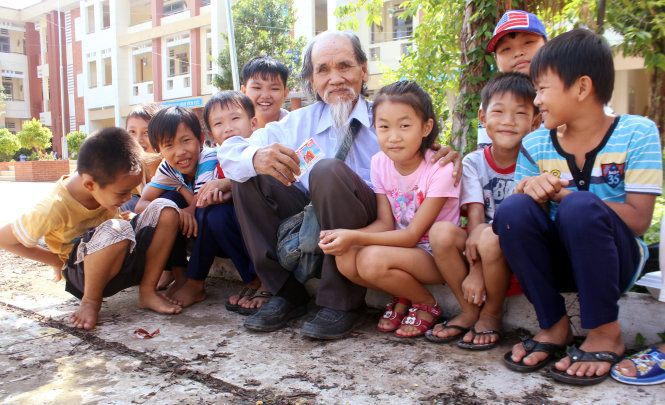 Các em thiếu nhi ở xã Phú Hữu luôn quấn quýt quanh ông Một mỗi khi ông ghé thăm, phát kẹo cho các em Ảnh: HẢI QUÂN