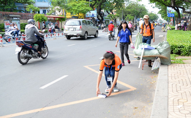 Các bạn trẻ nhặt rác trên đường Nguyễn Văn Cừ (Q.1, TP.HCM) hoạt động này giúp tạo thói quen giữ gìn vệ sinh chung trong cộng đồng - Ảnh: Hữu Khoa