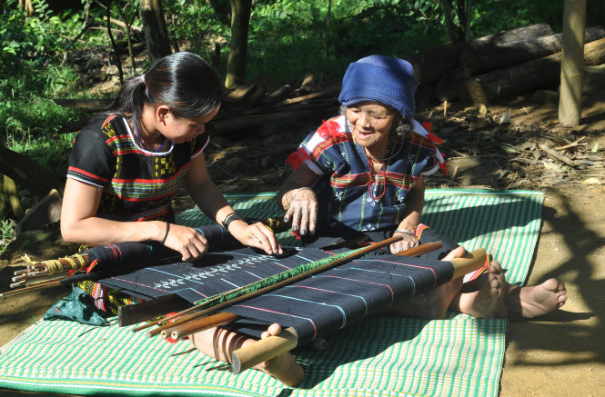 Cụ bà nghệ nhân Cơ Tu truyền dạy kỹ thuật dệt hoa văn gợn sóng cho thợ dệt trẻ - Ảnh: Tấn Vịnh