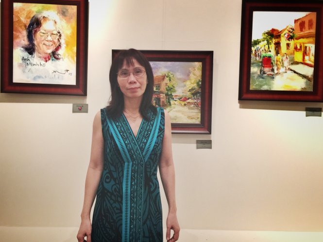 Họa sĩ Hoàng Anh bên những bức sơn dầu của chị - Ảnh: Minh Trang