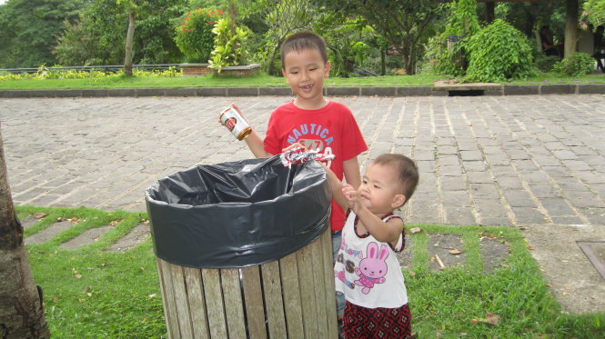 Cho trẻ học thêm những kỹ năng sống bằng cách dạy trẻ thu gom rác thải tại các công viên, góp phần bảo vệ môi trường - Ảnh: N.V.C.