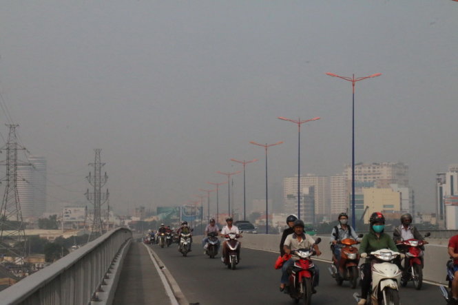 Các phương tiện di chuyển qua cầu Sài Gòn trong cảnh mù mịt - Ảnh: Yến Trinh
