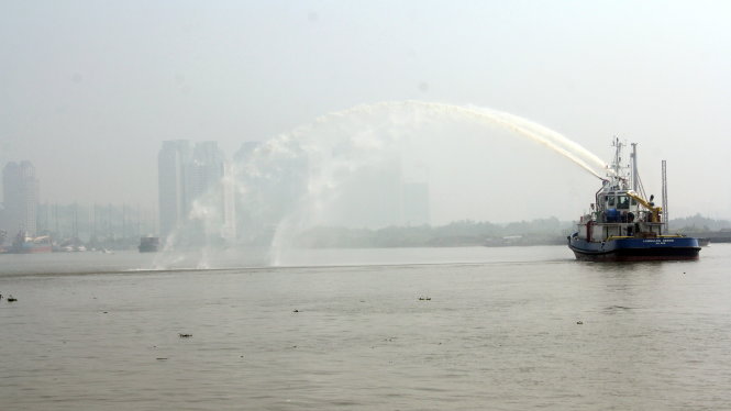 Gần 9 giờ sáng ngày 7-10, “mù khô” vẫn còn bao trùm nhiều nơi trên địa bàn TP. Trong ảnh một chiếc tàu diễn tập phun xịt nước trên sông Sài Gòn. Ảnh Quang Khải