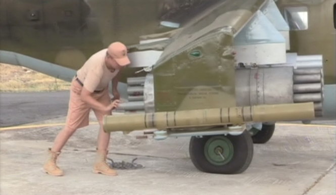 Nhân viên kỹ thuật của Nga nạp khí tài cho trực thăng tại căn cứ không quân Heymim trên lãnh thổ Syria ngày 6-10 - Ảnh: Reuters