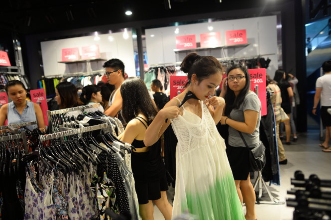 Khách hàng chọn mua quần áo của các thương hiệu nước ngoài tại trung tâm thương mại Bitexco, Q.1, TP.HCM -  Ảnh: Thuận Thắng