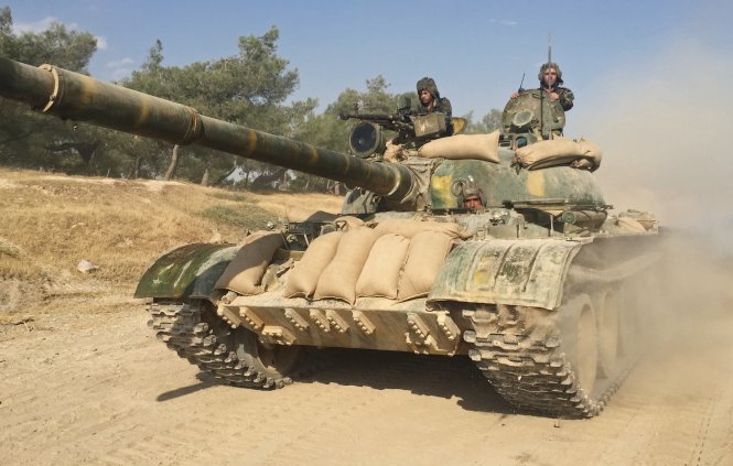 Binh sĩ Syria trên xe tăng ở tỉnh Hama trước lúc chuẩn bị cho cuộc tổng tiến công - Ảnh: AFP