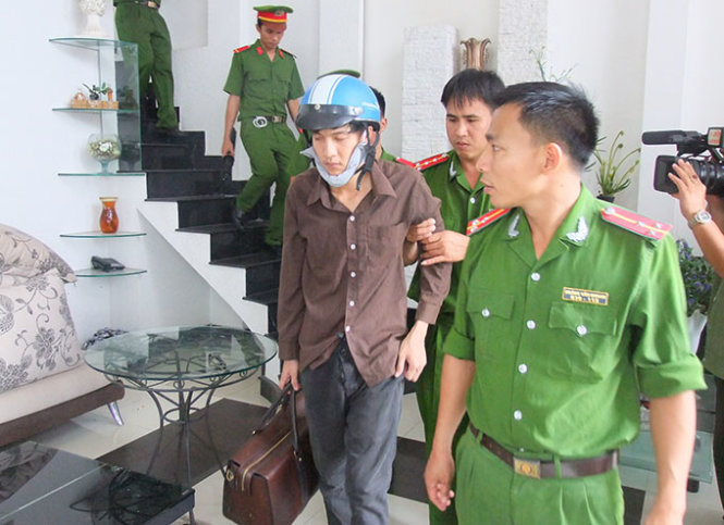 Bị can Dương (bên trái) thực nghiệm cầm túi đồ rời khỏi ngôi nhà sau khi gây án - Ảnh: N. NG.