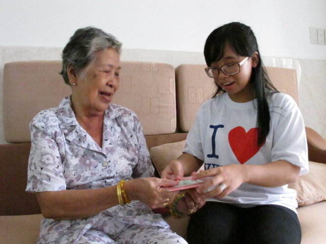Cô tổ trưởng tổ dân phố Phan Thiên Thanh đang trò chuyện với bác Trần Thị Tư để hỗ trợ bác làm thủ tục hưởng chế độ người cao tuổi - Ảnh: K.Aanh