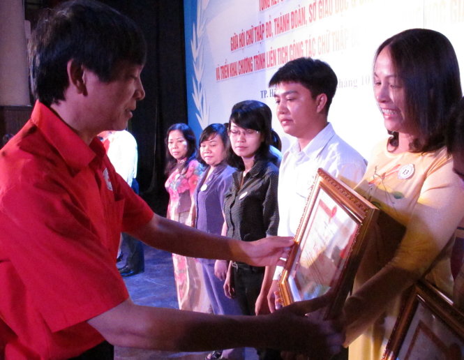 Ông Đoàn Văn Thái, phó chủ tịch Trung ương Hội Chữ thập đỏ VN, trao bằng khen của UBND cho các tập thể, cá nhân sáng 13-10 - Ảnh: K.Anh