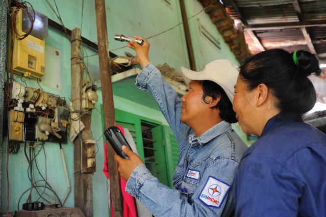 Nhân viên Công ty Điện lực Gò Vấp (TP.HCM) ghi số điện kế tại một hộ gia đình trên đường Quang Trung, P.10, Q.Gò Vấp sáng 16-10 - Ảnh: Tự Trung