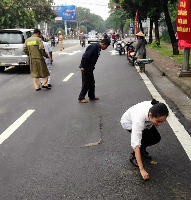 Người dân và cảnh sát giao thông cùng nhặt đinh trên đường Hà Nội