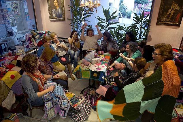 Nhóm phụ nữ ở  Villaverde del Rio (Tây Ban Nha) hẹn tại quán cà phê góc phố để cùng đan len làm nhân đạo - Ảnh: AFP