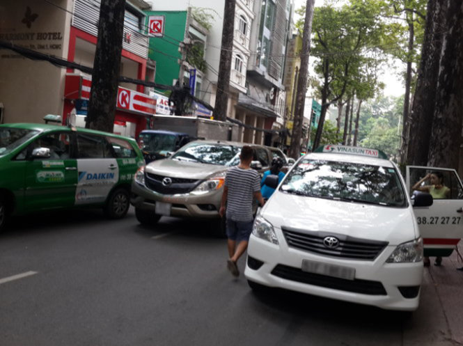 Một taxi dừng đón khách đã đậu ngược chiều trên đường Bùi Thị Xuân (Q.1) khiến xe cộ qua lại bị ùn ứ - Ảnh: Hữu Khoa