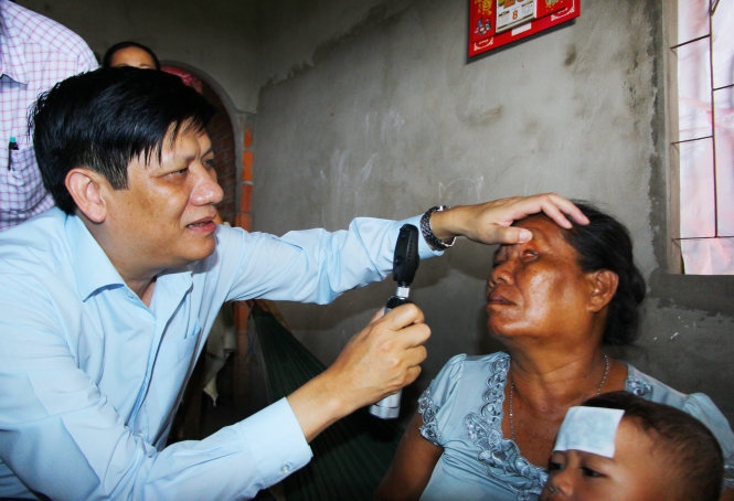 Thứ trưởng Bộ Y tế Nguyễn Thanh Long kiểm tra mắt cho bà Lý Thị Hiên ở ấp Trà Sết, xã Vĩnh Hải vào chiều 20-10. Bà Hiên bị mù cả hai mắt - Ảnh: Chí Quốc