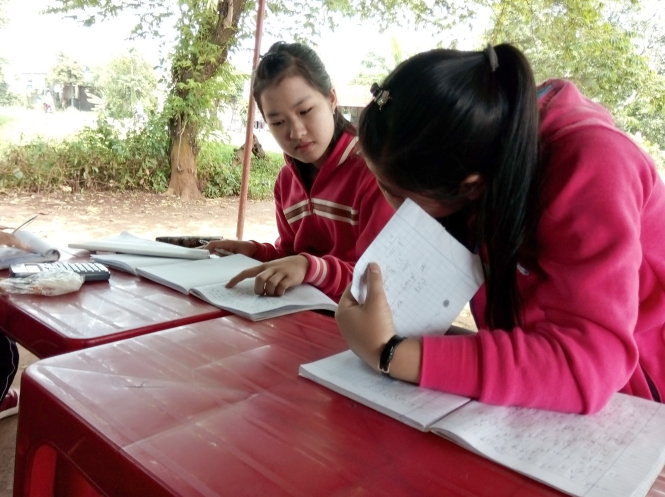 Nguyễn Thanh Tâm (trái) học bài cùng bạn ở quán tạp hóa  - Ảnh: K.Thịnh
