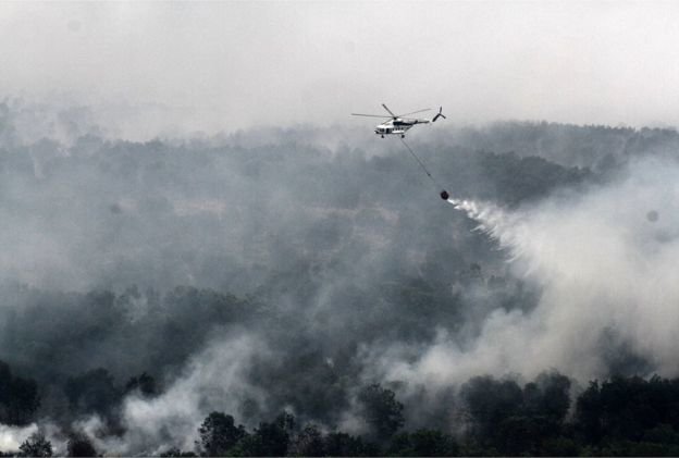 Trực thăng quân sự thả bom nước xuống các khu vực bị ảnh hưởng (AFP)