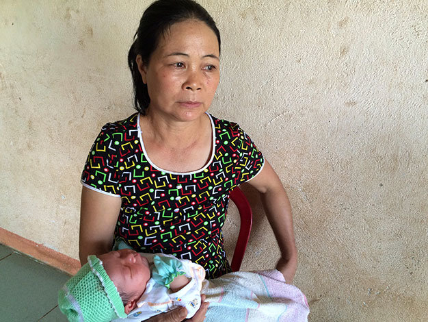 Bà Chu Thị Lô (54 tuổi, mẹ chồng chị T.) bế cháu nội mới sinh tại nhà con dâu thứ 2).