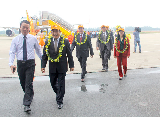 Những hành khách đầu tiên đặt chấn xuống cảng hàng không quốc tế Phú Bài được lãnh đạo tỉnh Thừa Thiên-Huế tặng hoa chúc mừng - Ảnh: Nguyên Linh
