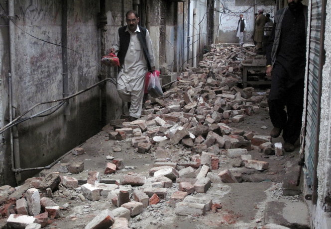 Gạch đá rơi xuống một ngõ hẻm ở Mingora, Pakistan sau động đất - Ảnh: Reuters