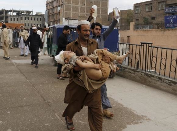 A man carries a boy, who was injured in an earthquake, at the Lady Reading hospital in Peshawar, Pakistan October 26, 2015.