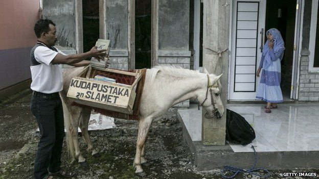 Ridwan Sururi và chú ngựa cưng Luna chở theo “thư viện di động” nhằm khuyến khích trẻ em tại Indonesia đọc sách nhiều hơn - Ảnh: BBC