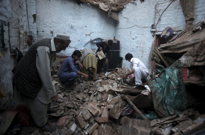 Tìm kiếm người mất tích trong đống đổ nát tại Peshawar, Pakistan - Ảnh: Reuters