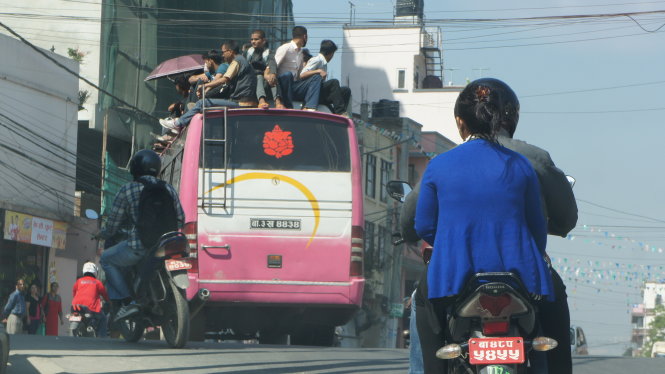 Xăng dầu thiếu thốn, xe cộ hạn chế đi lại, người dân phải chen chúc và leo lên nóc xe buýt công cộng để di chuyển ở thủ đô Kathmandu (ảnh chụp ngày 7-10) - Ảnh: Việt Phương