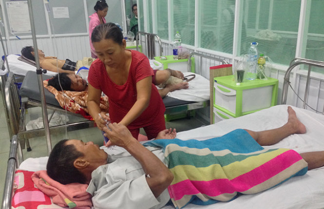 Bà Nguyễn Thị Dư chăm sóc cho chồng tại bệnh viện - Ảnh: Ngọc Khải