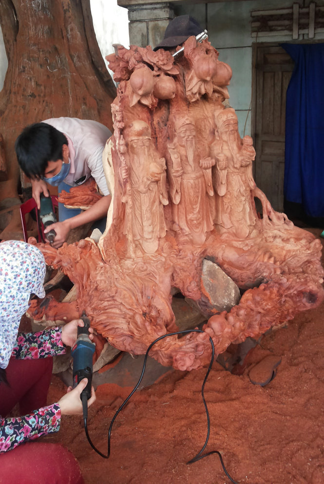 Gốc gỗ hương được đục làm tượng “tam đa” dùng để chưng trong nhà. Khi ra khỏi xưởng, bộ tượng này có giá không dưới 100 triệu đồng - Ảnh: Bá Dũng